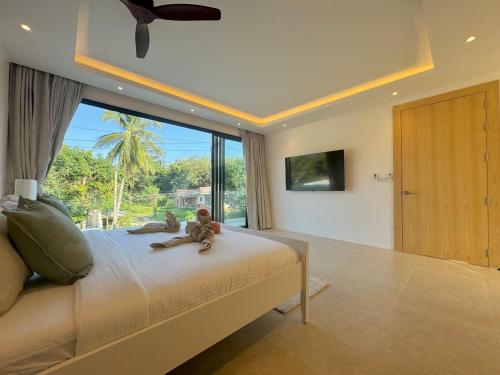 a bedroom with a bed with two monkeys sitting on it at Villa Malibu, Koh Samui in Amphoe Koh Samui