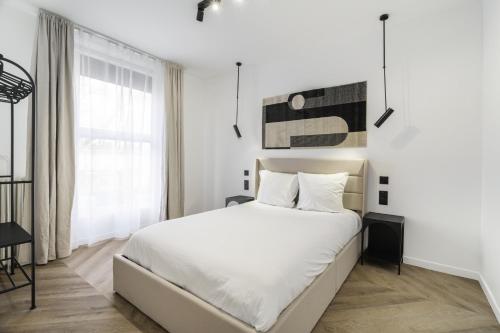 une chambre blanche avec un grand lit et une fenêtre dans l'établissement Appartement Parisien - Design - 4 couchages, à Paris