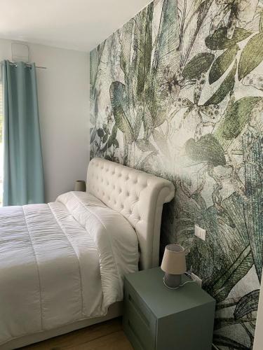 a bedroom with a white bed and a wall mural at Cassino - Appartamento Green - Parco del Gari in Cassino