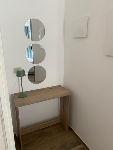 a mirror on a wall next to a wooden table at Cassino - Appartamento Green - Parco del Gari in Cassino