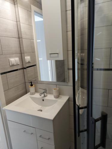 a white bathroom with a sink and a mirror at Dom Nad Potokiem Średnia Wieś in Hoczew