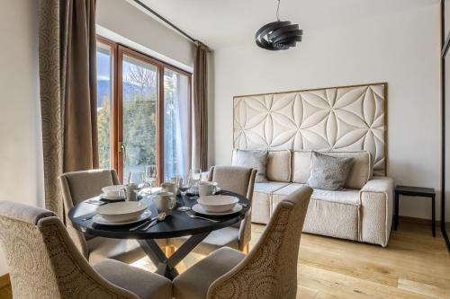 a living room with a table and chairs and a couch at Tatra Resort & SPA in Kościelisko