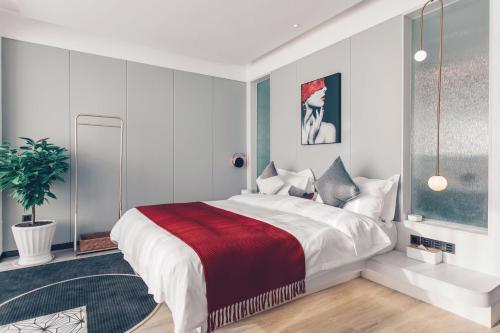 a bedroom with a large bed with a red blanket at Dali Mermaid Seascape Resort Hotel in Dali