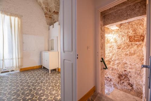 Habitación con pared de piedra y puerta. en Appartamento Matilde, en Racale
