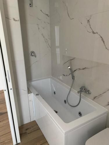a white bath tub with a shower in a bathroom at Cassino - Appartamento White - Parco del Gari in Cassino
