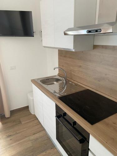 a small kitchen with a sink and a stove at Cassino - Appartamento White - Parco del Gari in Cassino