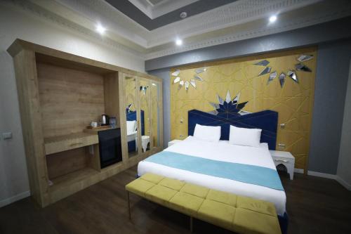 a bedroom with a bed with a blue and yellow wall at Antalya Grand Palace Hotel in Urganch