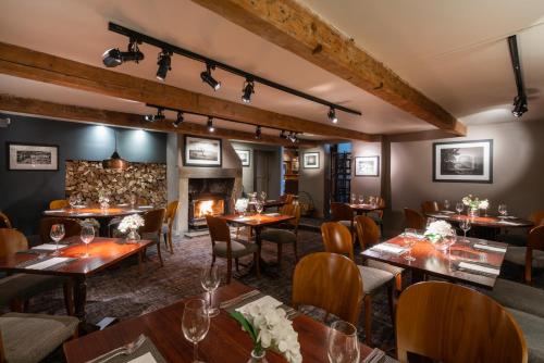 Un restaurante con mesas y sillas y chimenea. en The White Hart at Lydgate, en Oldham