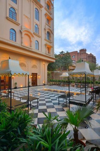a courtyard with tables and umbrellas next to a building at Hotel Chandra Raj Mahal in Bikaner