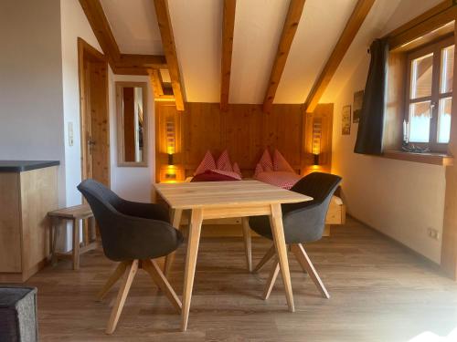 a dining room with a wooden table and chairs at Landhaus Elisabeth in Krün