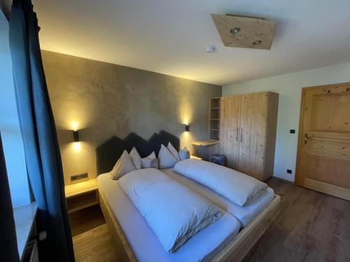a bedroom with a large bed with white pillows at Landhaus Elisabeth in Krün