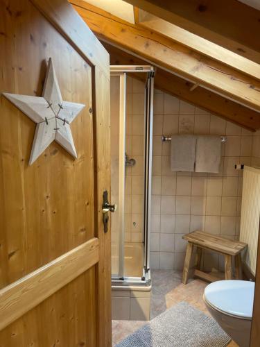 a bathroom with a wooden door with a star on it at Landhaus Elisabeth in Krün