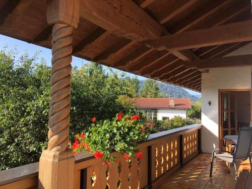 a wooden deck with a pergola and flowers at Landhaus Elisabeth in Krün