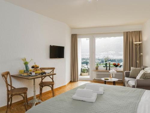 a living room with a bed and a table with chairs at Apartment Double Room Modern-11 by Interhome in Ascona