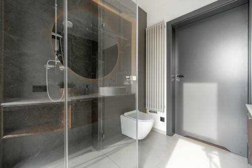 a bathroom with a toilet and a glass shower at Apartamenty Pod Grojcem - Dream Apart in Żywiec