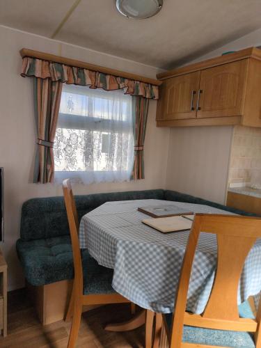 a small kitchen with a table and a couch at L&g FAMILY HOLIDAYS 8 BERTH SEALANDS FAMILYS ONLY AND THE LEAD PERSON MUST BE OVER 30 in Ingoldmells