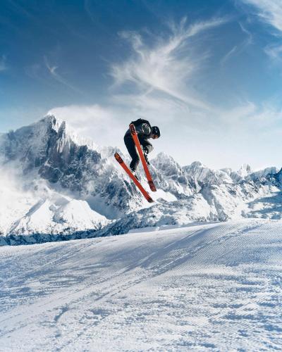 a person jumping in the air on skis in the snow at Hapimag Ferienwohnungen Zell am See in Zell am See
