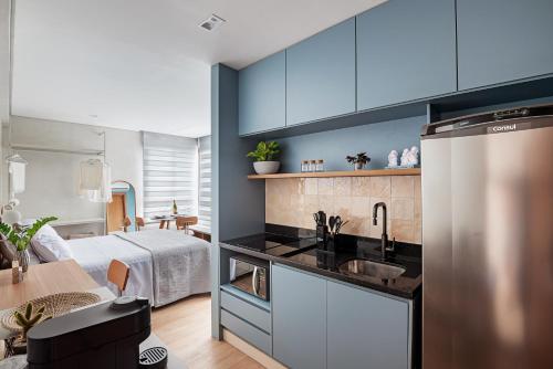 a kitchen with blue cabinets and a sink at Perto do mar Self check in Infraestrutura completa in Salvador