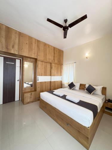 a bedroom with a large bed with a ceiling fan at Sai Grand Villa Hotel Near Bangalore Airport in Bengaluru