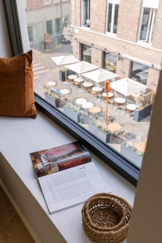 a window with a view of a tables and chairs at Margriet Apart-Suites in Ghent