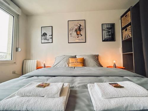 une chambre avec un lit avec deux serviettes dessus dans l'établissement Champagne T3 avec balcon et garage vue basilique, à Reims