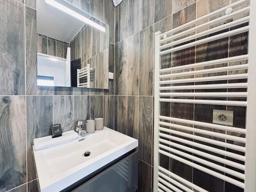 une salle de bain avec un lavabo blanc et un miroir dans l'établissement Champagne T3 avec balcon et garage vue basilique, à Reims