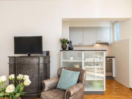 a living room with a chair and a flat screen tv at Apartment Junior Suite Modern-20 by Interhome in Ascona