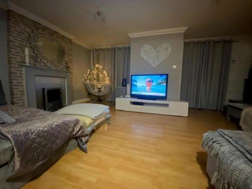 a large living room with a tv and a bed at Beautiful Views Welsh Retreat 2bedroom in Mountain Ash