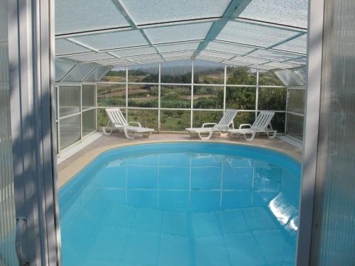 a swimming pool with two chairs at Holiday Home Das Serradas by Interhome in Vau