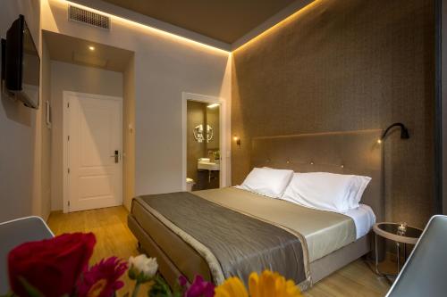 a bedroom with a bed and a television and flowers at Soggiorno Campos in Florence