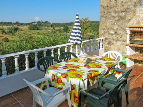 a table and chairs on a balcony with an umbrella at Holiday Home Das Serradas by Interhome in Vau