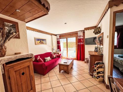 ein Wohnzimmer mit einem roten Sofa und einem Tisch in der Unterkunft Apartment Ginabelle 1-2 by Interhome in Chamonix-Mont-Blanc