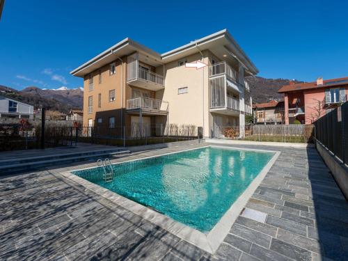 a house with a swimming pool in front of a building at Apartment Le Lac by Interhome in Gravedona