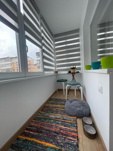 a room with a rug and a chair and a window at Casa-Alpin in Cîmpulung