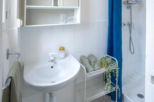 une salle de bain blanche avec un lavabo et une douche dans l'établissement Appartement 4 Guests Arras, à Paris