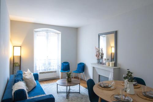 un salon avec un canapé bleu et une table dans l'établissement Appartement 4 Guests Arras, à Paris