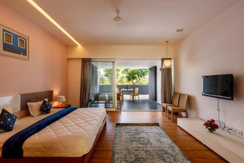 a bedroom with a large bed and a living room at St Jacinto Island Villa10 2Pools Bay View in Dabolim