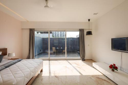 a bedroom with a bed and a view of a balcony at St Jacinto Island Villa10 2Pools Bay View in Dabolim