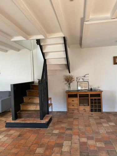 a room with a staircase and a table and a stair case at Maison de Bourg en Pierre au cœur de Plouharnel in Plouharnel