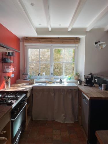a kitchen with a sink and a large window at Maison de Bourg en Pierre au cœur de Plouharnel in Plouharnel