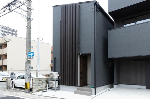 a black building with a door on a street at 堅粕汐風 K Ocean Breeze in Fukuoka