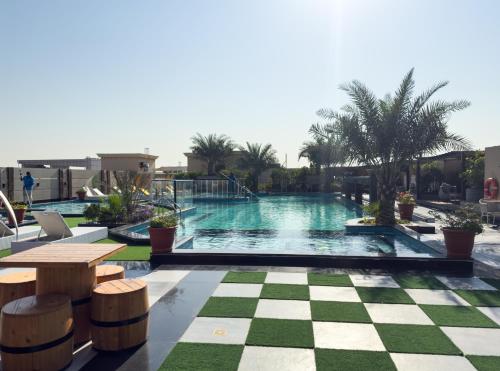 a swimming pool with a checkered floor and a resort at New Luxe 2 BR in Dubai