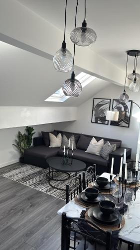a living room with a black couch and a table at City Centre Retreat Walk To Shops & Dining, Contractors Welcome in Bradford