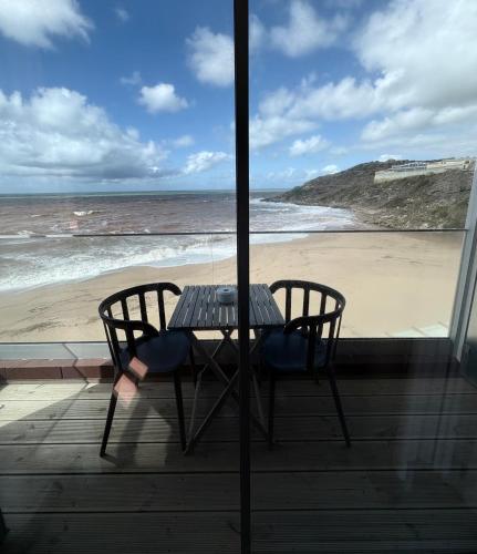 a table and chairs on a balcony with a beach at Promar - Eco Beach & Spa Hotel in Maceira