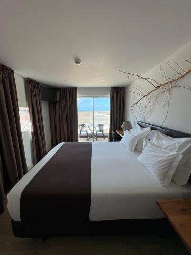 a bedroom with a bed with a view of the ocean at Promar - Eco Beach & Spa Hotel in Maceira