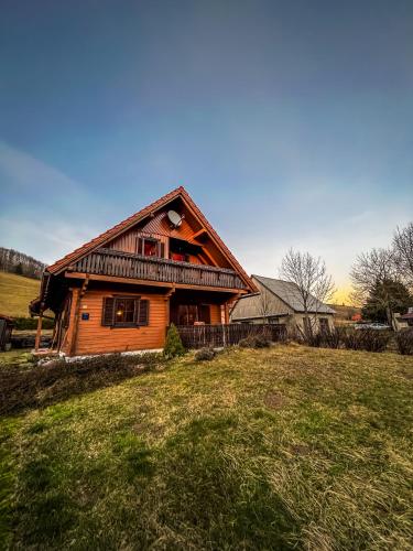 a wooden house in the middle of a field at Rustikalna kuća Snowdrop s kaminom u Begovom Razdolju, Gorski kotar in Begovo Razdolje
