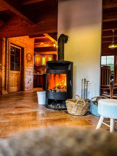 a fireplace in the middle of a living room at Rustikalna kuća Snowdrop s kaminom u Begovom Razdolju, Gorski kotar in Begovo Razdolje