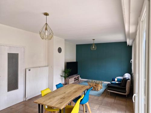 a living room with a wooden table and chairs at Maison Dijon proche centre ville in Talant