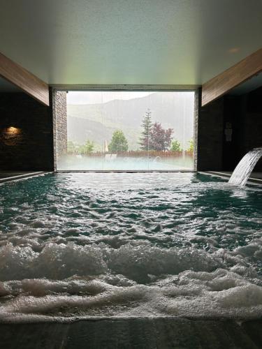 a pool of water in a room with a window at Aparthotel Siente Boí & SPA in Pla de l'Ermita