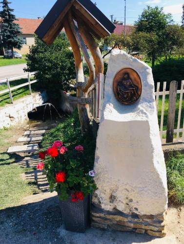a statue of a lion on a wall with flowers at Apartmán Zara in Dobrá Voda